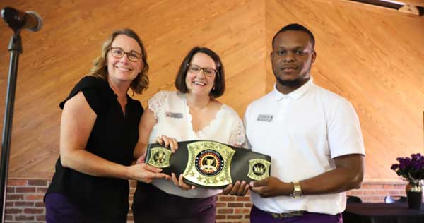 Staff hold their award at the Greatness Awards ceremony. 